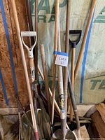 Cluster of long-handle shovels, rake, scoop shovel and broom