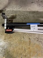 Folded Ryobi miter saw stand showing logo and rail