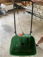 Front view of Scotts spreader showing hopper, handle and cable