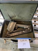 Stapler inside foam-lined case with label visible