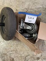 wheelbarrow wheel beside box of swivel casters