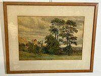 Full framed watercolour painting showing a rural landscape with stone buildings, tall trees, and open grassy area under a cloudy sky.