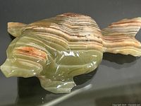 Side angle of the onyx seal figurine showing banded layers and polished surface.