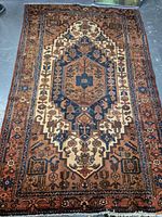 Full view of rectangular handmade Persian rug featuring a central medallion design and floral motifs