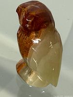 Front-left angle showing polished stone owl with brown and cream color bands.