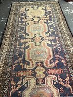 Full-length view of rug laid flat, showing overall geometric medallion pattern and borders