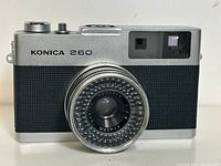 Front view of the Konica 260EE camera showing lens and body details.