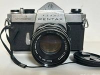 Front view of the vintage Pentax Spotmatic camera showing the Super-Takumar 55mm f/1.8 lens and the camera's metal and textured body.