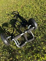Transport wheels laid out on grass showing full frame, wheels, foam padding, and straps.