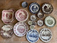 Top-down view of entire plate collection arranged on floor showing variety of colors, patterns and types including plates, bowls, cups, and platters.