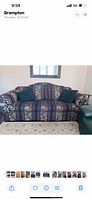 Front view of 3 seater couch with patterned upholstery and two green cushions