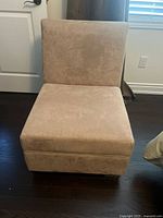 Front view of beige upholstered fabric chair showing cushion and fabric texture.