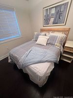 Twin bed made up with Ralph Lauren plaid duvet cover, pillowcases, and sheets in a neutral bedroom.