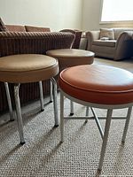 Three stools grouped near sofa showing colors and legs