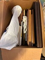 Box containing multiple wooden frames in different finishes