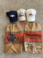 Group shot of three Broncos caps and two burlap potato sacks