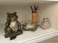 Group shot showing three glass frog figures and wicker vase with dried botanicals