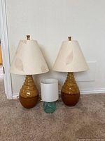Two brown ceramic lamps with shades and teal lamp between