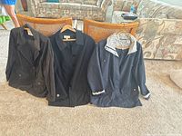 Three jackets displayed front view on hangers