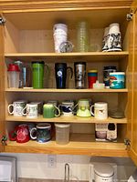 Cabinet shelves with mugs, tumblers, insulated cups, sippy cups and plastic containers