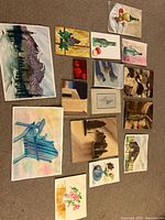 Overall view of fifteen paintings laid out on carpet