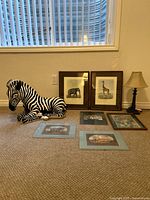 Group shot showing ceramic zebra, two framed prints, lamp, and three matted prints