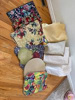 Pile of assorted placemats, folded tablecloths visible