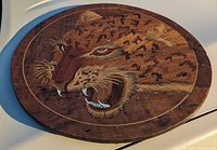 Full view of round inlaid wood plaque on light surface