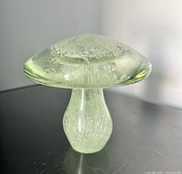 Front view of light green glass mushroom paperweight