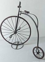 Full view of metal penny-farthing sculpture on stand