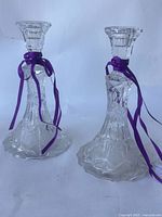 Pair of tall cut crystal candlesticks with purple ribbons