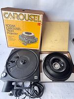 Projector, slide tray and box laid out to show overall contents