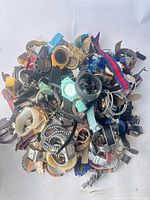 Pile of mixed wristwatches showing variety of styles and materials