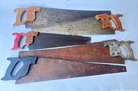 Five hand saws laid out showing full blades and handles