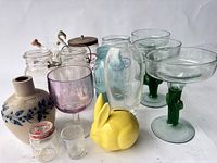 Group shot of all glassware, pottery vase, bunny bank and jars