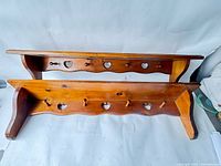 Both pine shelves stacked showing heart cutouts and pegs
