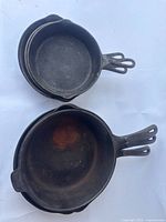 Six nested cast iron skillets showing overall lot