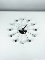 Full front view of chrome radial clock on white background