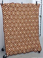 Full view of the tablecloth hanging, showing the hexagon pattern and scalloped edges.