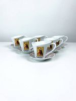 Front and angled view of the 6 white ceramic espresso shot mugs with Flamenco dancer graphic and matching saucers arranged on a white surface, showing the full set.