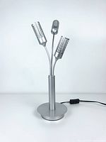 Front view of the vintage 3-arms microphone desk lamp showing the circular base, power cord with inline switch, and three flexible microphone-shaped light heads in silver finish.