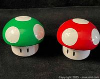 Green and red mushroom tins with caps on