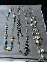 Three necklaces laid out on grey surface