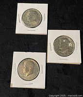 Obverse sides of three dated half dollar coins in flips