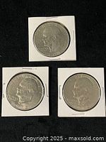 Obverse views of three Eisenhower dollars dated 1972, 1972, 1976 in flips