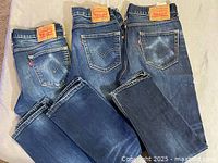 Back view of three pairs showing leather patches, red tabs