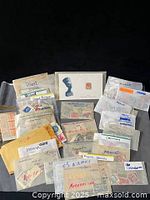 Overall view of lot showing multiple labeled glassine envelopes of stamps and Nefertiti souvenir card