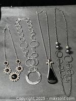 All four silver-tone necklaces displayed together