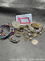 Overall view of assorted jewelry, tokens and patch