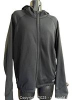Front view of black REI hooded zip-up jacket on mannequin